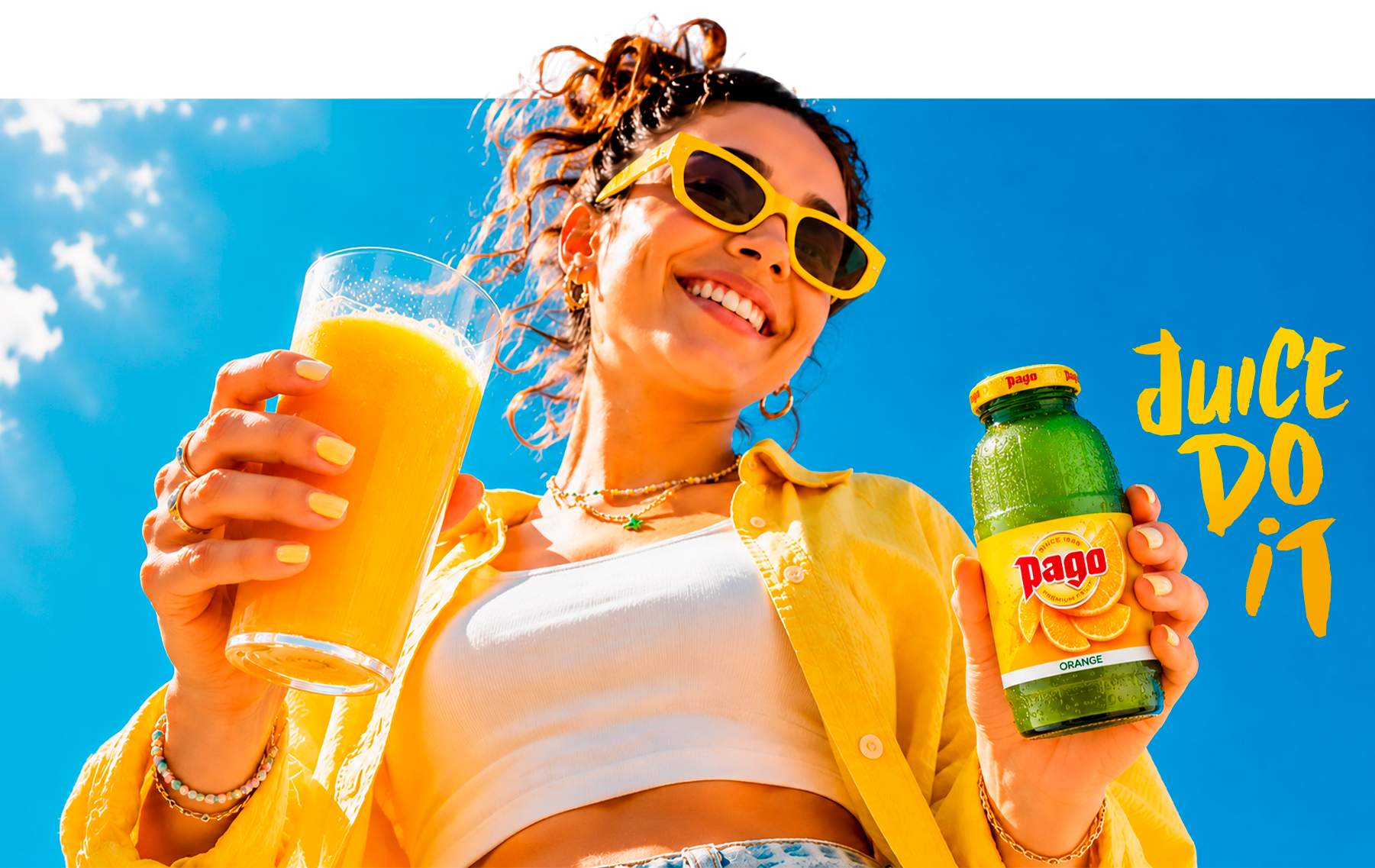 Young woman holding a glass of orange juice and a Pago Orange bottle, 'Juice do it'